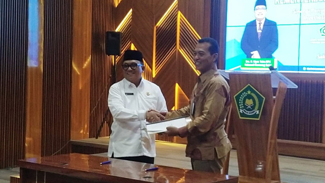 Kepala Kemenag Sulawesi Utara, Hi Ulyas Taha, dan Pimpinan PT Pegadaian Wilayah V, Pratikno, saat penandatanganan kerja sama produk investasi emas untuk calon jemaah haji dengan tujuan memudahkan pengumpulan ongkos pemberangkatan haji. 