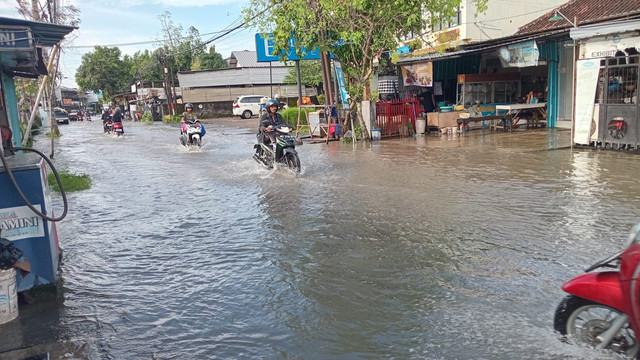 Pengendara motor melintasi banjir di Jalan Gunung Salak, Kota Denpasar, Bali, Rabu (12/2). Foto: Denita BR Matondang/kumparan