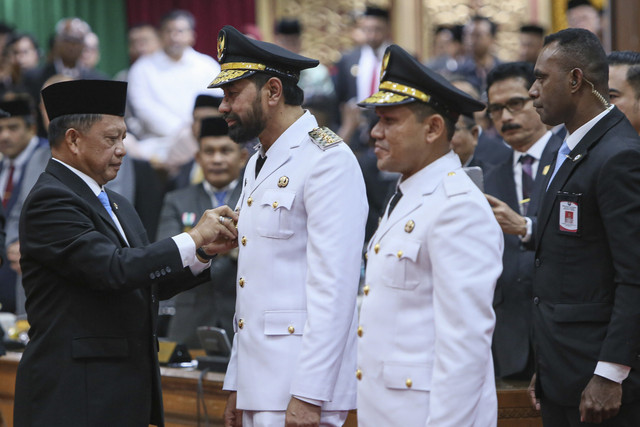 Menteri Dalam Negeri Muhammad Tito Karnavian menyematkan tanda pangkat kepada Gubernur Aceh Muzakir Manaf (kedua kiri) saat pelantikan gubernur dan wakil gubernur Aceh dalam Sidang Paripurna DPR di Aceh, Banda Aceh, Rabu (12/2/2025). Foto: Khalis Surry/ANTARA FOTO