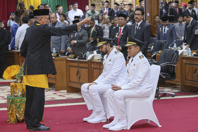 Wali Nanggroe Aceh Tgk Malik Mahmud Al Haytar melakukan peusijuk (tradisi adat Aceh) kepada Gubernur dan Wakil Gubernur Aceh Muzakir Manaf (kedua kanan) dan Fadhlullah saat pelantikan dalam Sidang Paripurna DPR di Banda Aceh, Aceh, Rabu (12/2/2025). Foto: Khalis Surry/ANTARA FOTO