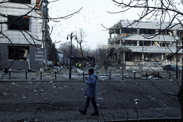 Seorang warga melintas dengan latar belakang bangunan yang hancur akibat serangan rudal Rusia ke Ukraina di Kyiv, Ukraina, Rabu (12/2/2025). Foto: Gleb Garanich/Reuters