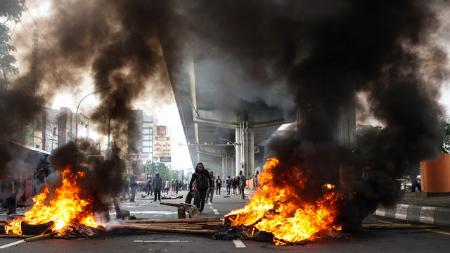 Massa memblokir jalan dengan membakar ban bekas dan bambu untuk menghalangi proses eksekusi lahan di Jalan AP Pettarani, Makassar, Sulawesi Selatan, Kamis (13/2/2025). Foto: ANTARA FOTO/Arnas Padda