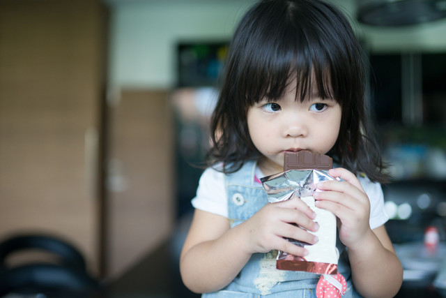 Ilustrasi anak makan cokelat. Foto: MIA Studio/Shutterstock