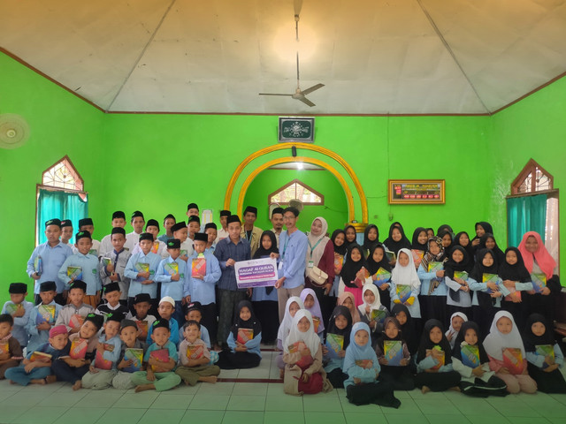 Gambar 1: penyerahan wakaf mushaf Al-Quran di Madrasah Diniyah Takmiliyah Hikmatul Ulum (sumber: dokumen pribadi)