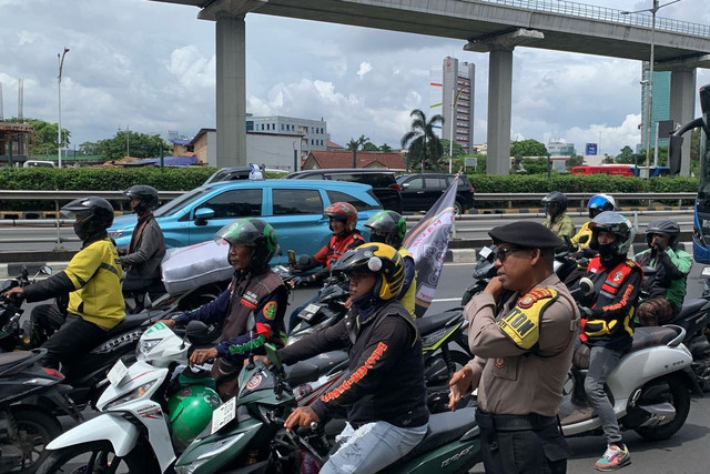 Massa aksi unjuk rasa ojol dari Serikat Pekerja Angkutan Indonesia (SPAI) tiba jelang aksi unjuk rasa di depan Kantor Kemnaker, Jakarta, Senin (17/2/2025). Foto: Luthfi Humam/kumparan