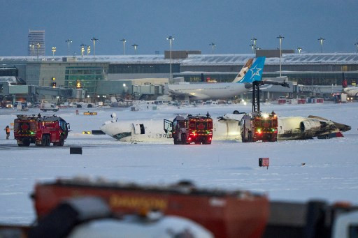 Pesawat jenis CRJ-900 milik Delta Air Lines terbalik saat mendarat darurat di Bandara Toronto Pearson, Kanada, Senin (17/2). Foto: GEOFF ROBINS / AFP