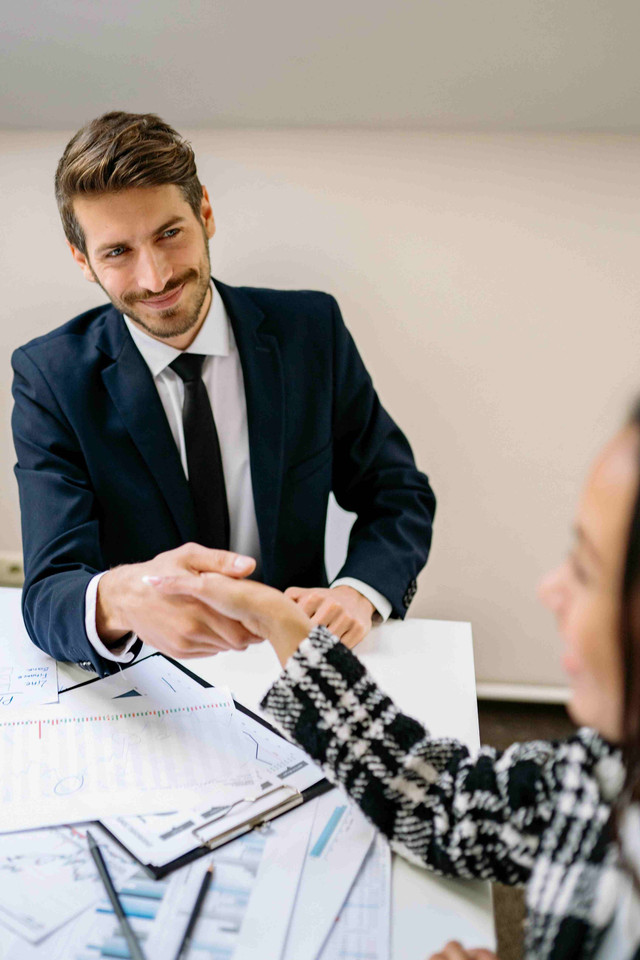 https://www.pexels.com/photo/a-smiling-man-shaking-hands-with-a-person-at-an-office-7693157/