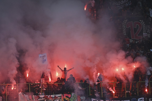 Suporter menyalakan flare usai laga lanjutan Liga 1 antara Persija Jakarta melawan Persib bandung di Stadion Patriot Candrabhaga, Bekasi, Jawa Barat, Minggu (16/2/2025). Foto: Akbar Nugroho Gumay/ANTARA FOTO