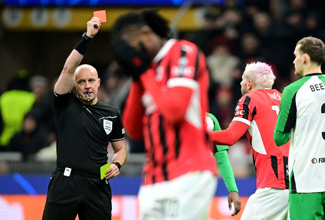 Wasit Szymon Marciniak memberi kartu merah ke Theo Hernandez usai laga AC Milan vs Feyenoord dalam leg kedua playoff Fase Gugur Liga Champions 2024/25 pada Rabu (19/2) dini hari WIB. Foto: REUTERS/Daniele Mascolo