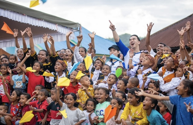 Aktor Indonesia Joe Taslim beserta istri Julie Taslim dan Direktur Eksekutif Plan Indonesia Dini Widiastuti berfoto dengan anak-anak di Nagekeo, NTT – dok: Yayasan Plan International Indonesia