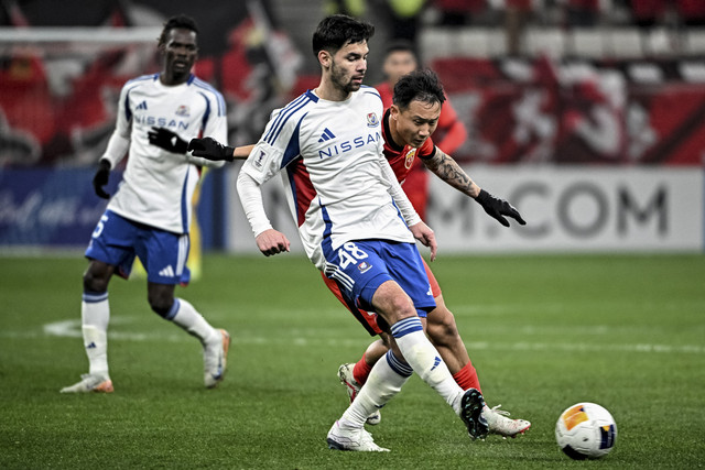 Sandy Walsh dari Yokohama F. Marinos (C) berebut bola dengan Feng Jin dari Shanghai Port (R) selama pertandingan sepak bola Liga Champions AFC antara Yokohama F. Marinos dari Jepang dan Shanghai Port FC dari Tiongkok di Shanghai pada 19 Februari 2025 Foto: Stringer/AFP