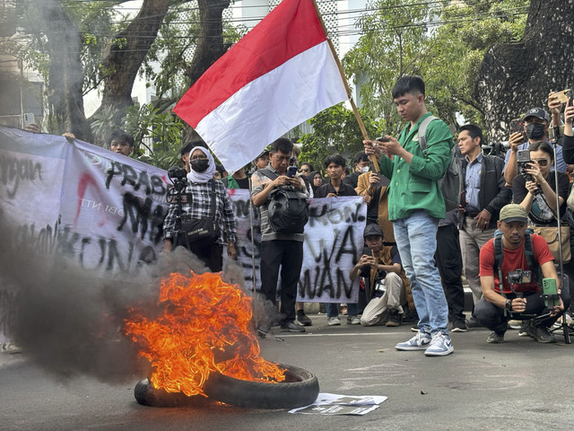 Massa aksi dari Universitas Nasional langsung membakar ban sesampainya di Patung Kuda, Jakarta pada Kamis (20/2/2025). Foto: Abid Raihan/kumparan