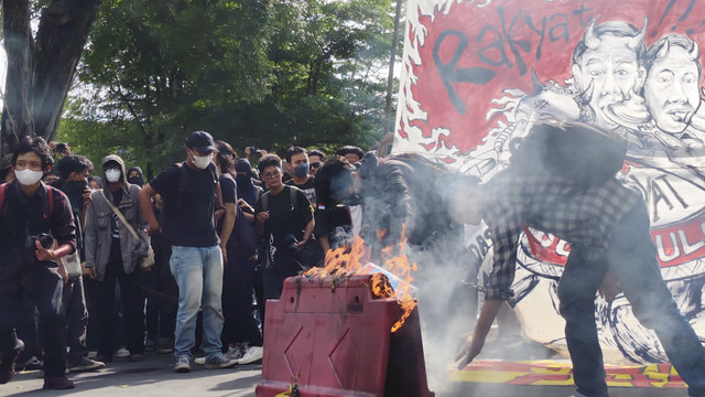 Massa Jogja Memanggil membakar water barrier atau pembatas jalan di depan Istana Kepresidenan Yogyakarta atau Gedung Agung, Kamis (20/2/2025). Foto: Arfiansyah Panji Purnandaru/kumparan