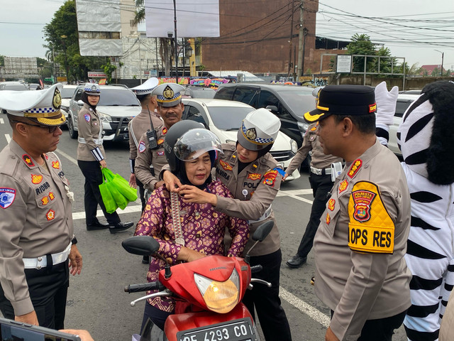 Polresta Bandarbagikan helm gratis untuk pengendara yang tertib berlalu lintas. | Foto: Sinta Yuliana/Lampung Geh