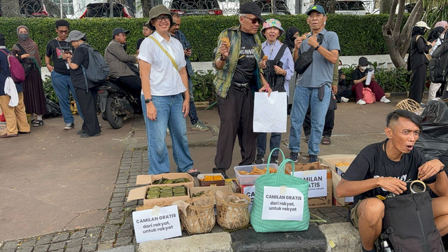 Ibu Nada dan kawan-kawan bagi-bagi cemilan gratis untuk massa demo #IndonesiaGelap di Patung Kuda, Jakarta Pusat pada Jumat (21/2). Foto: Abid Raihan/kumparan