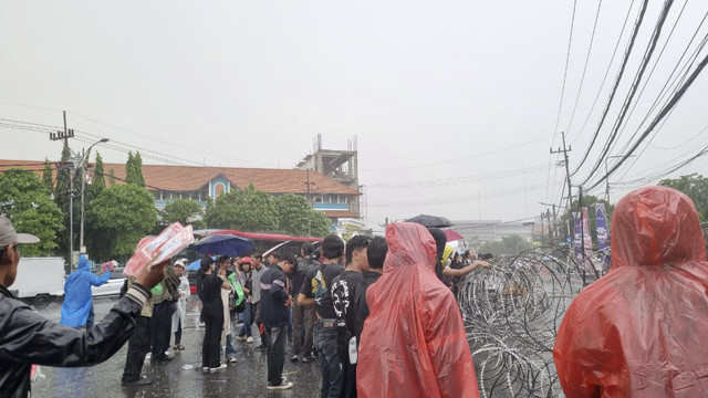 Massa tetap bertahan di depan Gedung DPRD Jawa Timur meski diguyur hujan. Foto: Farusma Okta Verdian/kumparan