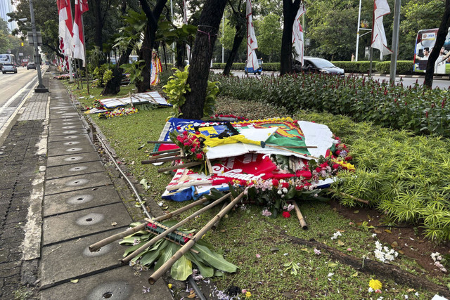 Sejumlah karangan bunga hancur di depan Balai Kota, Jakarta Pusat, diduga dihancurkan mahasiswa massa aksi #IndonesiaGelap saat long march ke Patung Kuda, Jakarta pada Jumat (21/2/2025).  Foto: Abid Raihan/kumparan