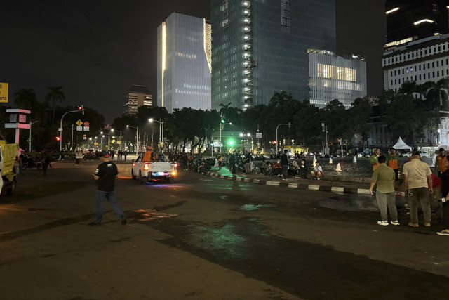 Massa aksi #IndonesiaGelap bubarkan diri dari bundaran Patung Kuda, Jakarta Pusat, petugas PPSU mulai bersihkan jalan.  Foto: Abid Raihan/kumparan