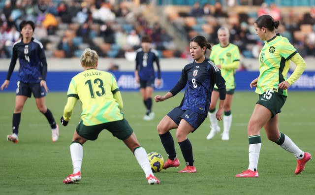 Gelandang Timnas Wanita Jepang Manaka Matsukubo menghadapi pemain Timnas Wanita Australia Tameka Yallop.  Foto: Reuters/Thomas Shea-Imagn Images