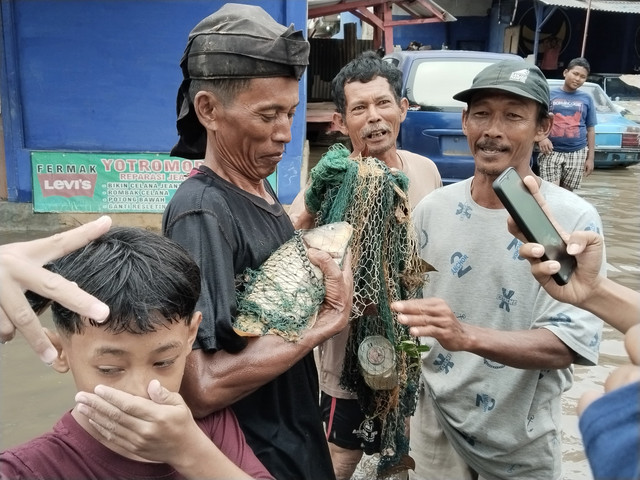 Warga Tanjung Senang, yang berhasil menjaring ikan di tengah-tengah banjir | Foto : Eka Febriani / Lampung Geh