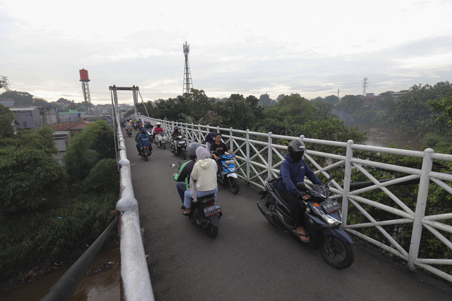 Melewati Jembatan: Pengendara motor melewati jembatan penyeberangan sungai di Pasar Minggu, Jakarta. Foto: Dicky Adam Sidiq/kumparan