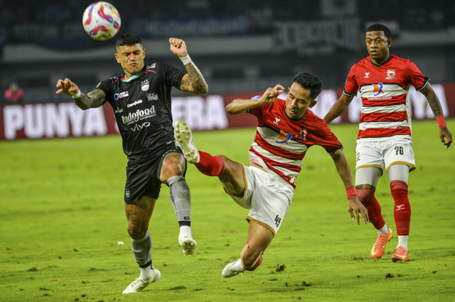 Pesepak bola Persib Bandung Ciro Alves (kiri) berebut bola dengan pesepak bola Madura United Taufik Hidayat (tengah) saat menjalani pertandingan BRI Liga 1 di Stadion Gelora Bandung Lautan Api (GBLA), Bandung, Jawa Barat, Sabtu (22/2/2025). Foto: Raisan Al Farisi/ANTARA FOTO