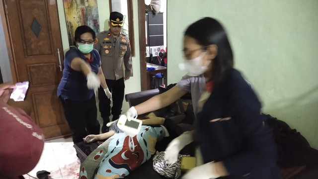 Petugas memeriksa seorang ibu yang tewas dalam rumahnya di Jimbaran, Bali. Foto: Dok. Istimewa