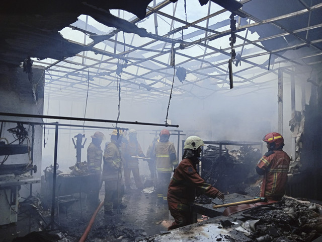 Petugas pemadam melakukan pendinginan di tempat laundry yang kebakaran di Jalan Simo Tambaan 2 No. 69, Kelurahan Putat Jaya, Kecamatan Sawahan, Kota Surabaya pada Senin (24/2/2025). Foto: Dok. DPKP Kota Surabaya