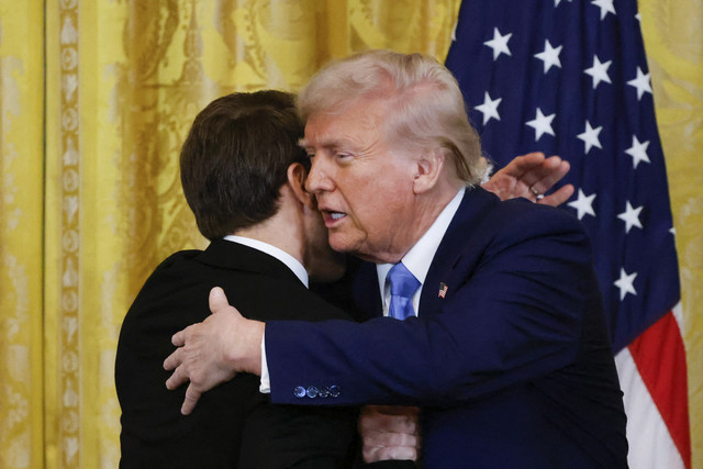 Presiden Amerika Serikat Donald Trump berjabat tangan dengan Presiden Prancis Emmanuel Macron saat pertemuan delegasi Amerika Serikat dengan Prancis di Gedung Putih, Amerika Serikat, Senin (24/2/2025). Foto: Ludovic Marin/AFP