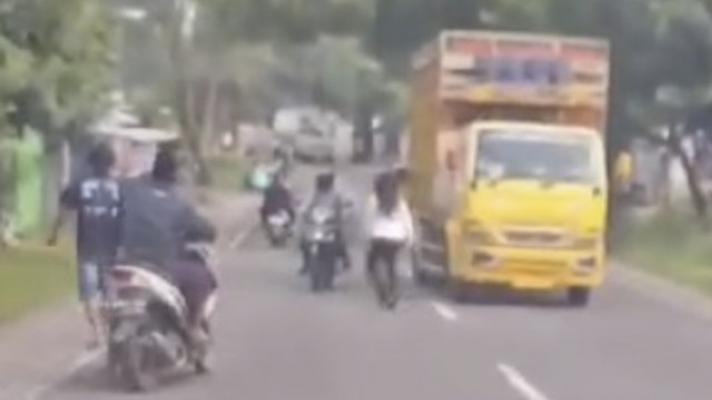 Seorang wanita mencoba menabrakkan diri ke pengendara jalan yang melintas di Jalan Raya Jombang-Babat, Lamongan. Foto: Istimewa