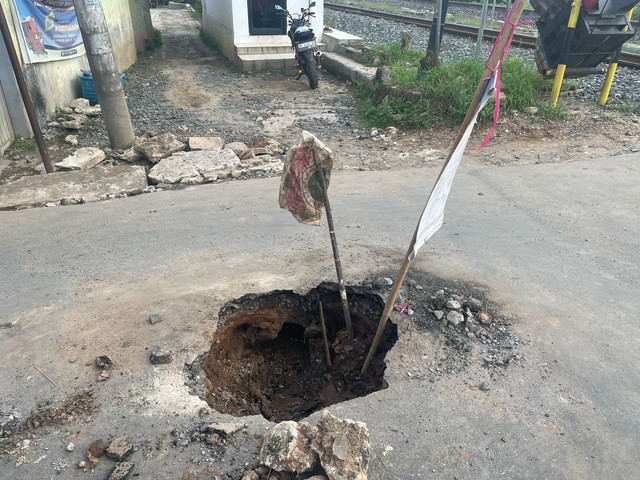 Jalan berlubang di dekat perlintasan kereta api Kampung baru, Labuhan ratu, Bandar Lampung. | Foto: Eva Nurdiah/ Lampung Geh