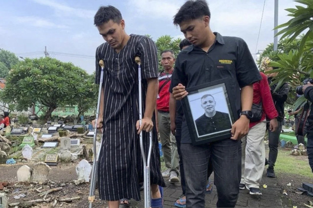 Putra almarhum Bejo Sugiantoro, Rachmat Irianto (kiri) saat mengiringi jenazah sang ayah ke tempat persemayaman di TPU Geluran, Sidoarjo, Rabu (26/2/2025). Foto: Fahmi Alfian/ANTARA