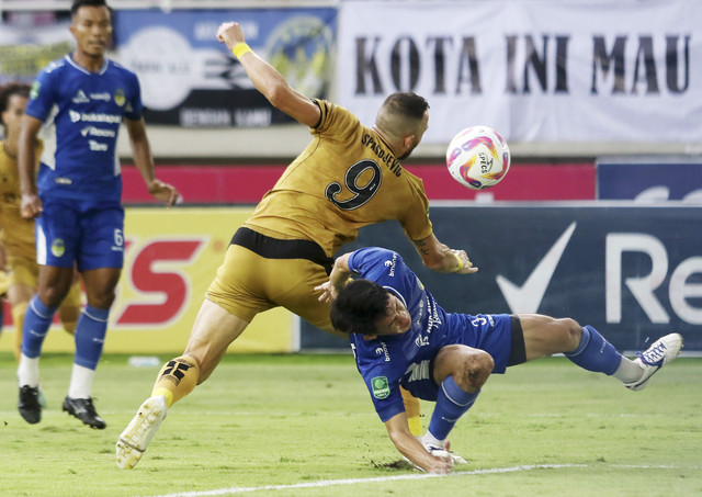 Pesepak bola PSIM Yogyakarta Yusaku Yamadera (kanan) berebut bola dengan pesepak bola Bhayangkara FC Ilija Spasojevic (tengah) saat pertandingan final Pegadaian Liga 2 di Stadion Manahan, Solo, Jawa Tengah, Rabu (26/2/2025). Foto: Mohammad Ayudha/ANTARA FOTO