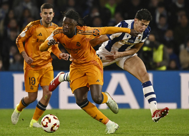 Pemain Real Madrid Eduardo Camavinga berebut bola dengan pemain Real Sociedad Nayef Aguerd pada pertandingan Copa del Rey di Stadion Anoeta, San Sebastian, Spanyol, Rabu (26/2/2025). Foto: Ander Gillenea/AFP