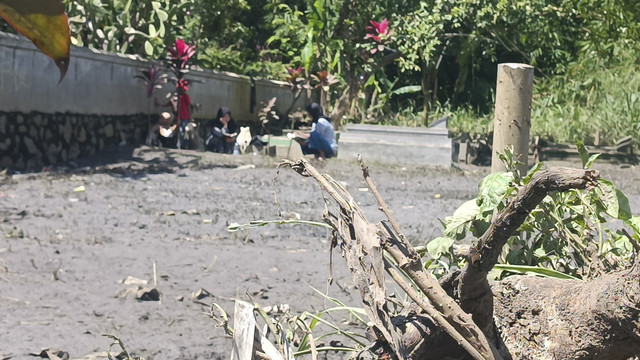 Sejumlah orang tetap menjalankan tradisi nadran atau ziarah kubur jelang bulan Suci Ramadan di TPU di Bojongsoang, Kabupaten Bandung, yang sempat terendam banjir imbas tanggul Sungai Cipundung jebol.  Foto: Robby Bouceu/kumparan