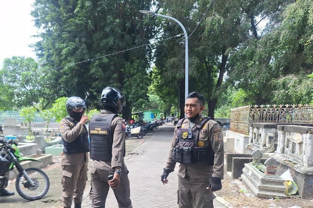 Satpol PP sedang razia pengemis musiman di salah satu area makam di Surabaya. Foto: Diskominfo Surabaya 