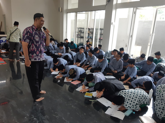 Syaiful Bachri Ketua Komisi Nasional Perlindungan Anak (Komnas PA) Surabaya saat mendampingi para santri menulis surat untuk Komdigi. 