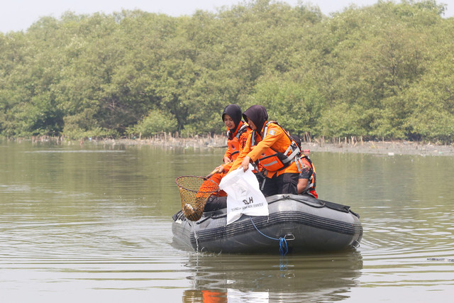 Menjaring sampah di Kebun Raya Mangrove (KRM) Gunung Anyar Kota Surabaya. Foto: Diskominfo Surabaya 