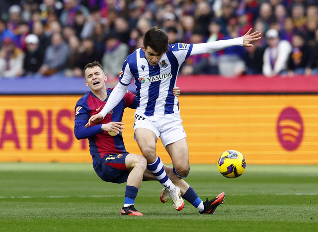 Marc Casado dari FC Barcelona beraksi dengan pemain Real Sociedad Pablo Marin pada pertandingan Liga Spanyol antara Barcelona vs Real Sociedad di Estadi Olimpic Lluis Companys, Barcelona, Spanyol, Minggu (2/3/2025). Foto: Albert Gea/REUTERS