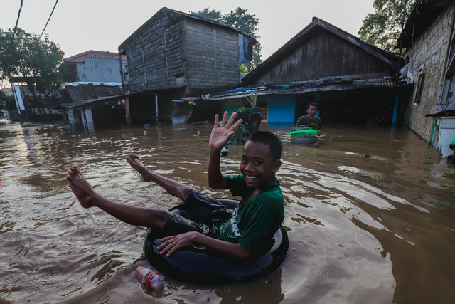 Seorang anak bermain saat banjir merendam permukiman warga di Pejaten Timur, Pasar Minggu, Jakarta Selatan, Senin (3/3/2025). Foto: Jamal Ramadhan/kumparan