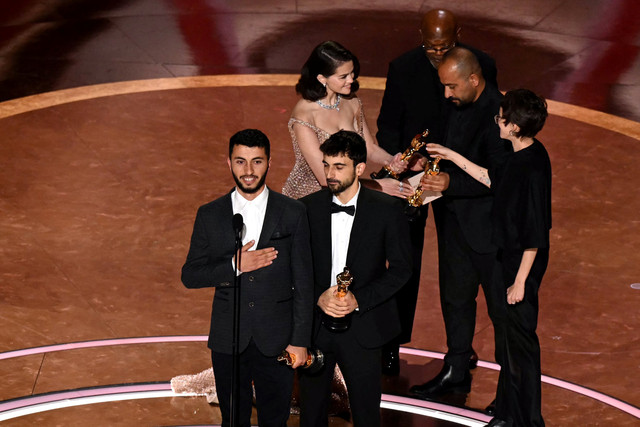 Jurnalis dan pembuat film Israel Yuval Abraham (kanan) dan jurnalis dan pembuat film Palestina Basel Adra menerima penghargaan pada ajang Academy Awards Tahunan ke-97 di Dolby Theatre, Beverly Hills, California, AS, Minggu (2/3/2025). Foto: Patrick T. Fallon/AFP