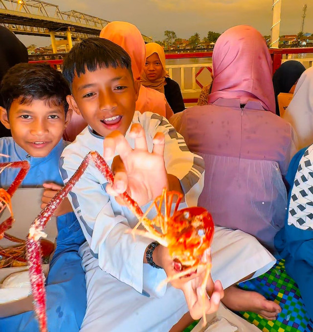 Anak-anak Kampung Beting Pontianak menunjukkan Udang Galah yang menjadi menu buka puasa mereka. Foto: Dok. Rumah Zakat Kalbar