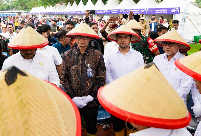 Menteri Koordinator Pangan Zulkifli Hasan (kanan) bersama Retail Banking Bank Mandiri, Aquarius Rudianto (kedua dari kiri) pada kegiatan panen raya di Ngawi, Jawa Timur, Senin (3/3). Foto: Dok. Bank Mandiri