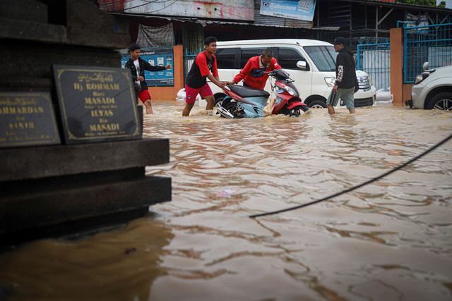 Warga mendorong motor saat banjir merendam Jatiasih, Bekasi, Selasa (4/3/2025). Foto: Iqbal Firdaus/kumparan