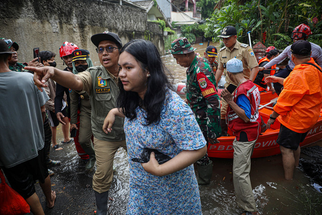 Camat Pesanggrahan, Agus Ramdani bersama petugas mengevakuasi warga yang terdampak banjir di kawasan perumahan IKPN Jakarta Selatan, Selasa (4/3/2025). Foto: Aditia Noviansyah/kumparan