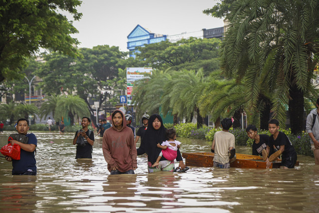 Sejumlah warga melintas saat banjir di Grand Galaxy City, Kota Bekasi, Jawa Barat, Selasa (4/3/2025).  Foto: Iqbal Firdaus/kumparan