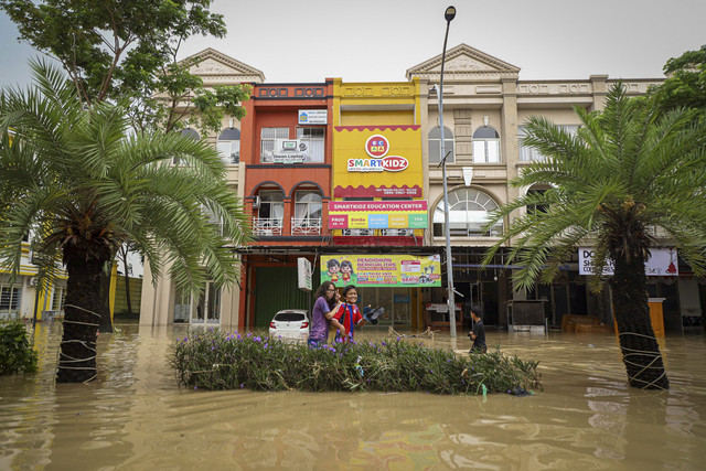 Sejumlah warga melintas saat banjir di Grand Galaxy City, Kota Bekasi, Jawa Barat, Selasa (4/3/2025).  Foto: Iqbal Firdaus/kumparan