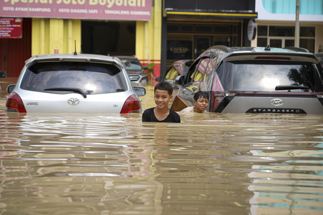 Sejumlah warga melintas saat banjir di Grand Galaxy City, Kota Bekasi, Jawa Barat, Selasa (4/3/2025).  Foto: Iqbal Firdaus/kumparan