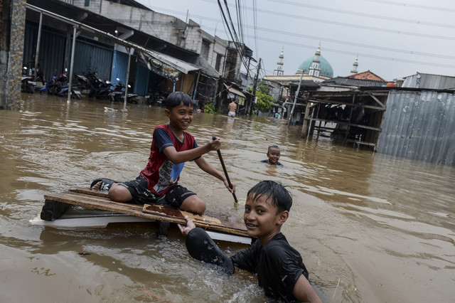 Anak-anak bermain air saat terjadi banjir di Petir, Kota Tangerang, Banten, Selasa (4/3/2025).  Foto: Putra M. Akbar/ANTARA FOTO 