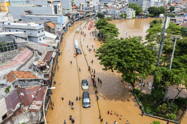 Foto udara sejumlah mobil melintasi banjir akibat luapan air Sungai Ciliwung di Jatinegara, Jakarta, Selasa (4/3/2025). Foto: Bayu Pratama S/ANTARA FOTO